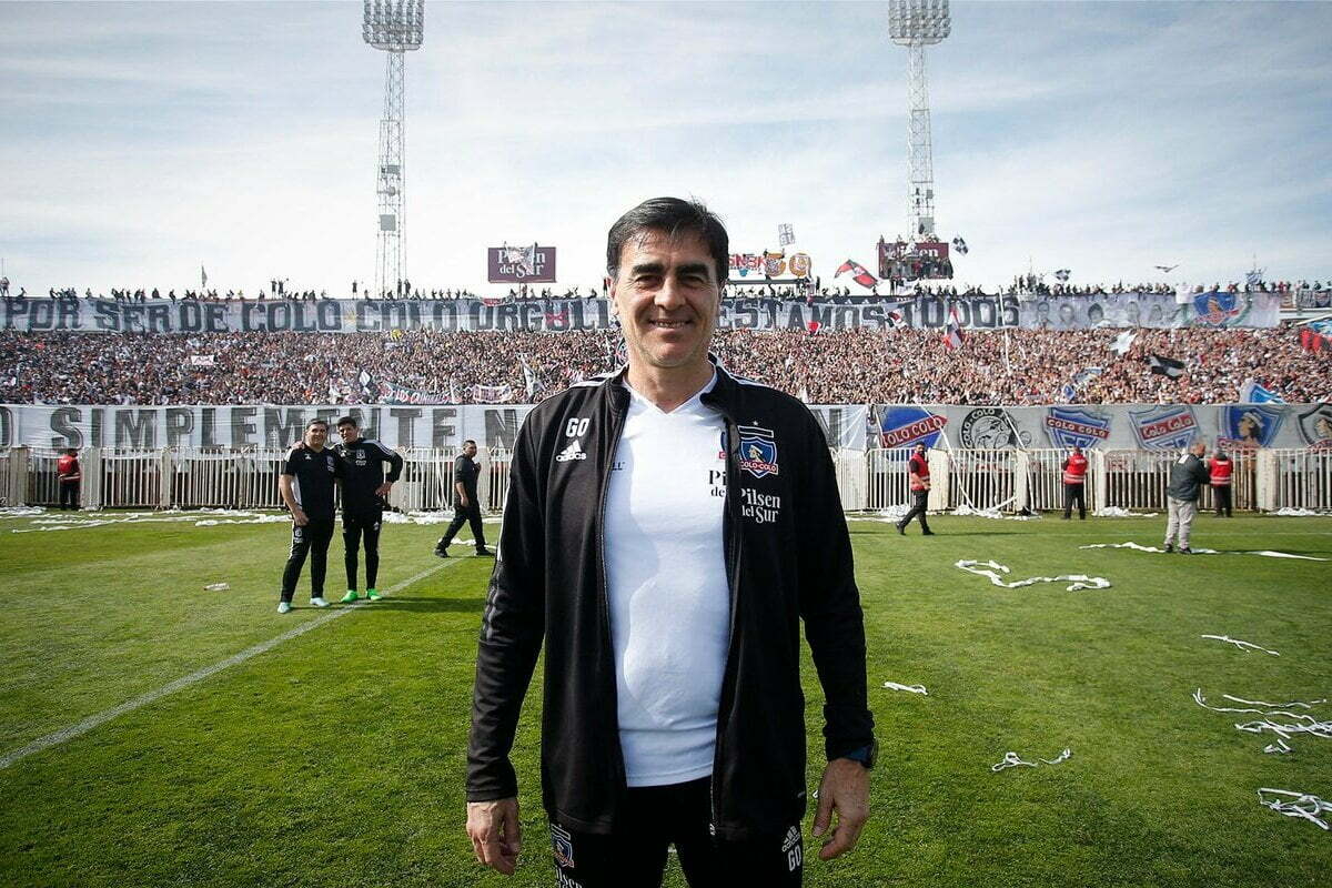 Gustavo Quinteros en la cancha del Estadio Monumental con un arengazo de fondo