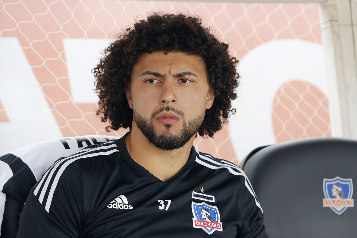 Maximiliano Falcón mirando un partido de Colo-Colo desde la banca de suplentes.