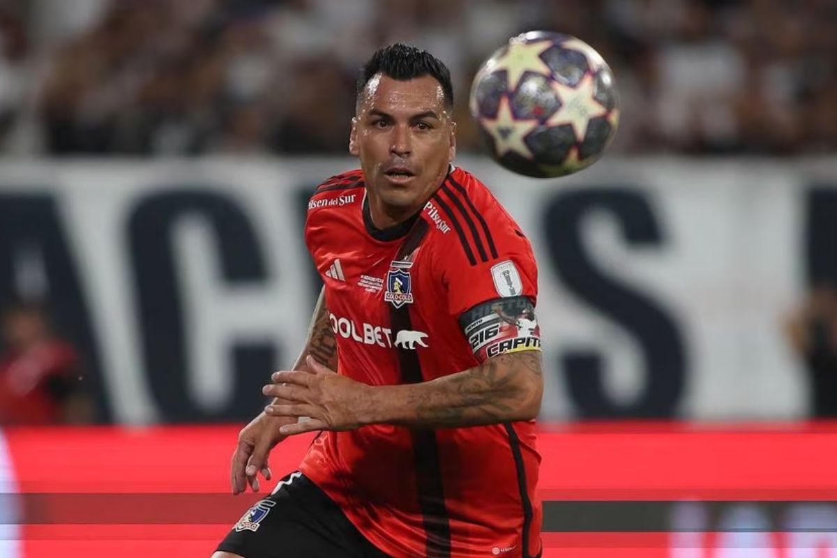 Esteban Paredes mirando fijamente el balón con la camiseta de Colo-Colo durante su partido de despedida.