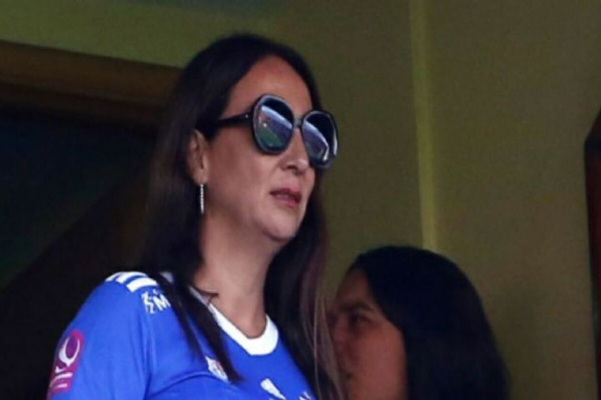 Cecilia Pérez, integrante del directorio de Azul Azul, observando un partido de Universidad de Chile junto a la camiseta de los azules.