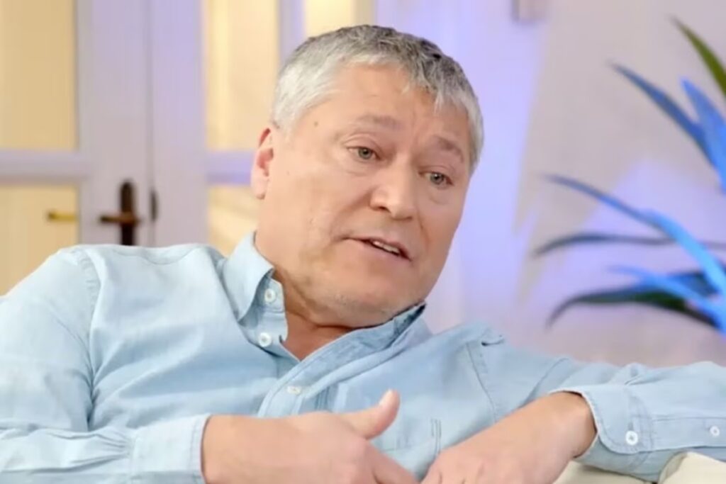 Patricio Yáñez concediendo una entrevista en un sillón con una camisa azul.