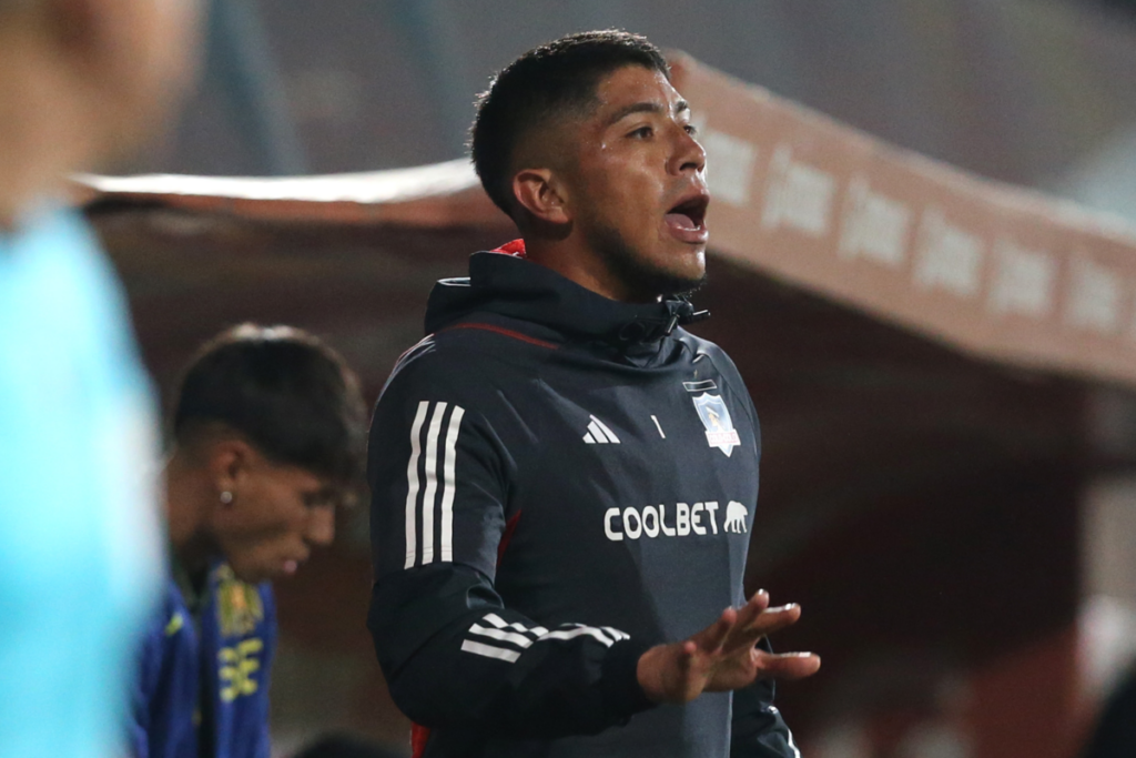 Brayan Cortés repartiendo instrucciones desde la banca de suplentes de Colo-Colo en el duelo ante Unión Española.