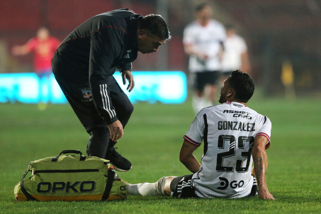 Ramiro González tendido sobre el campo de juego, debido a una lesión que lo obligó a abandonar el partido de Colo-Colo vs Unión Española, disputado en el Estadio Santa Laura.