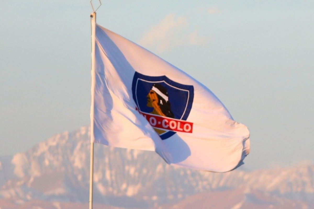 Bandera con el logo de Colo-Colo en ella flamea con la cordillera de fondo.