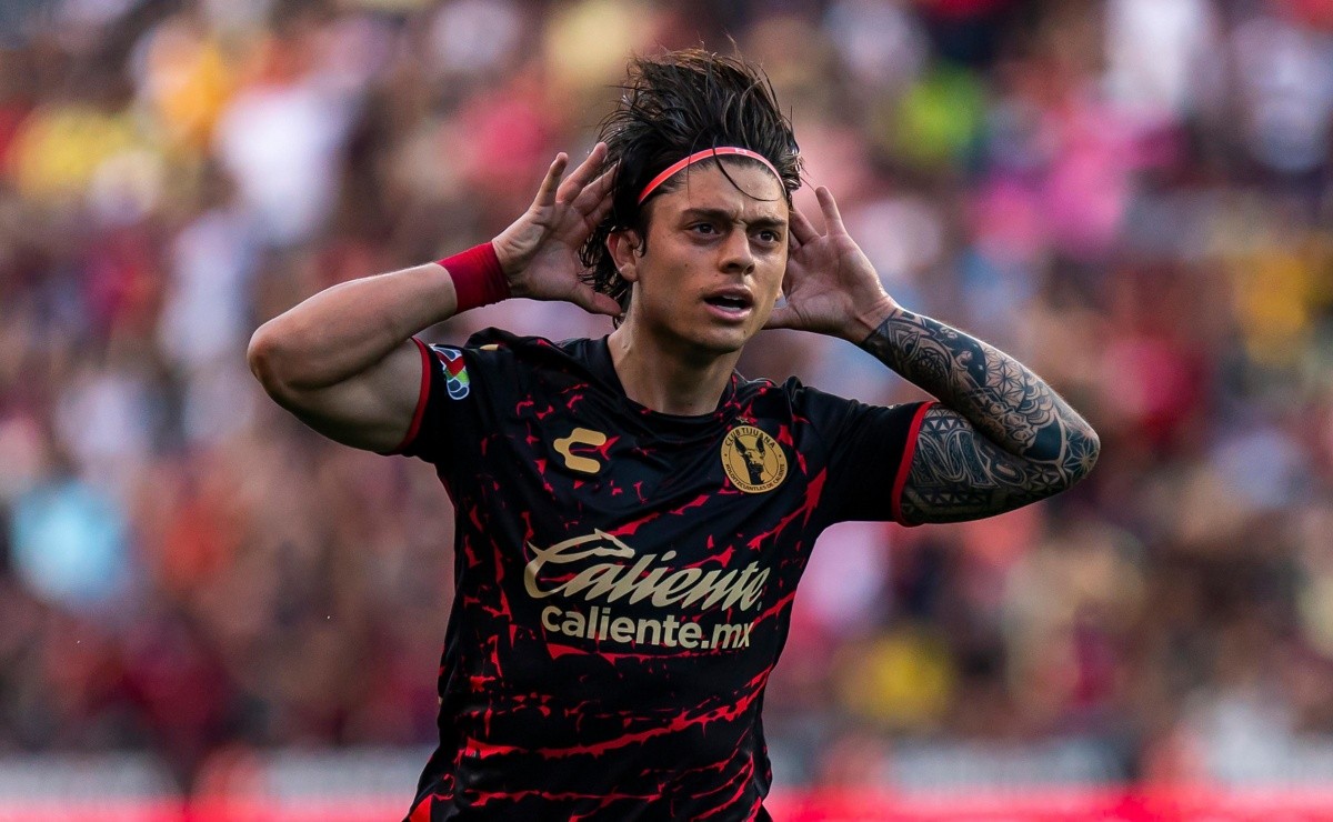 Joaquín Montecinos celebrando un gol con la camiseta del Xolos de Tijuana con las manos en la cabeza.