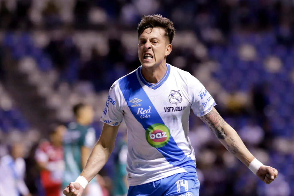 Pablo Parra celebran un gol con la camiseta del Club Puebla en el fútbol mexicano.