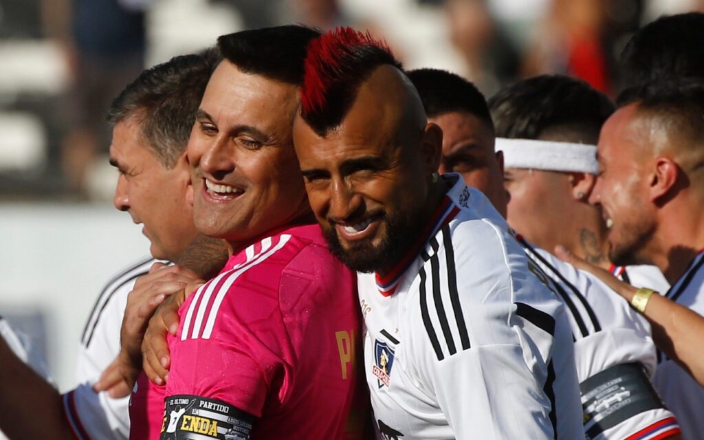 Arturo Vidal entre risas y abrazos con Justo Villar mientras tienen la camiseta de Colo Colo