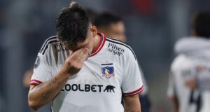 Futbolista de Colo Colo con la cabeza abajo y su mano en el rostro
