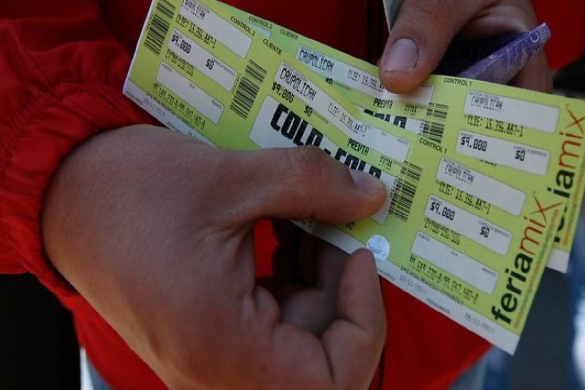 Persona con varias entradas para partido de Colo-Colo en sus manos.