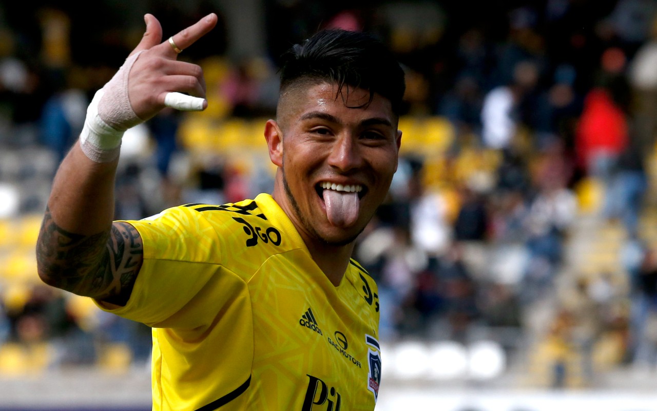 Brayan Cortés sacando la lengua y levantando la mano con la camiseta de Colo Colo