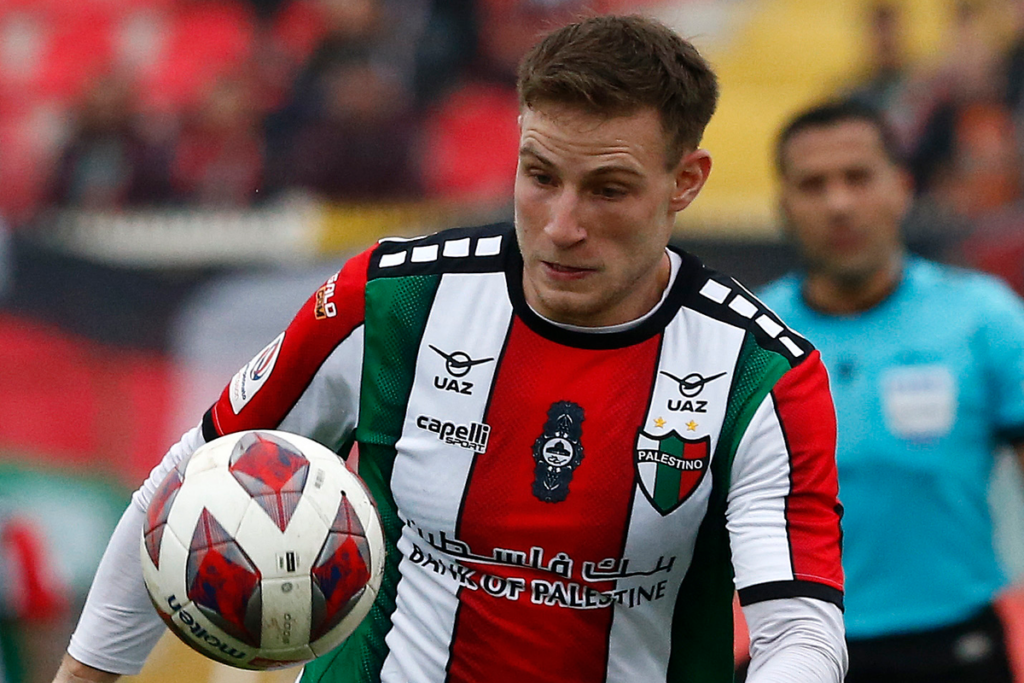 Bruno Barticciotto concentrado en el balón en medio de un partido de Palestino.