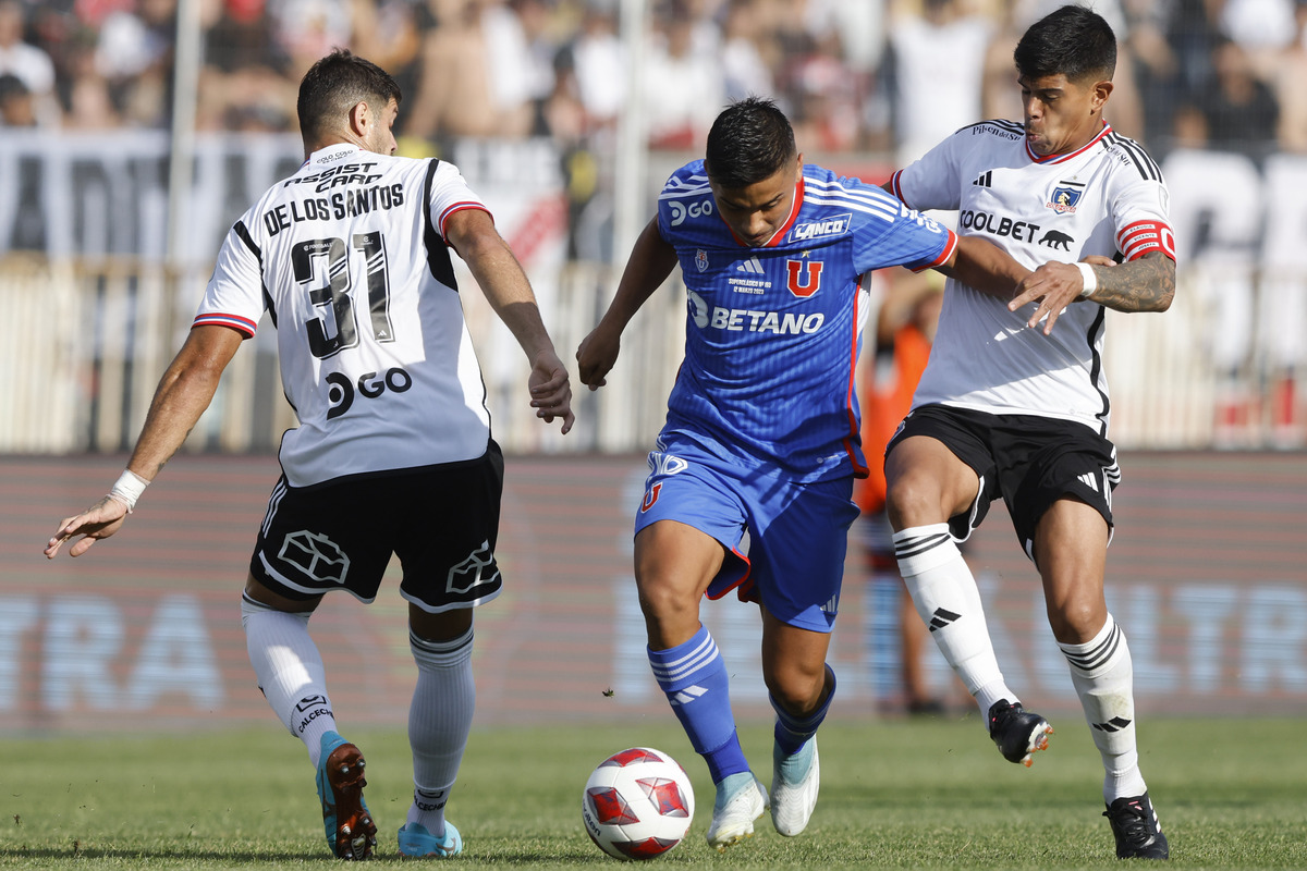 Jugadores de Colo-Colo y Universidad de Chile disputando un balón en un Superclásico.