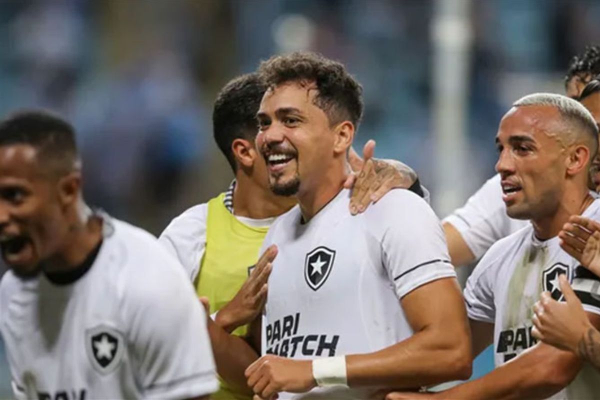 Futbolistas de Botafogo sonriendo en cancha con camiseta blanca