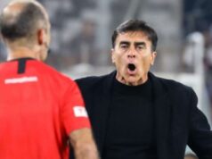 Gustavo Quinteros con cara de sorpresa y la boca abierta mirando al árbitro