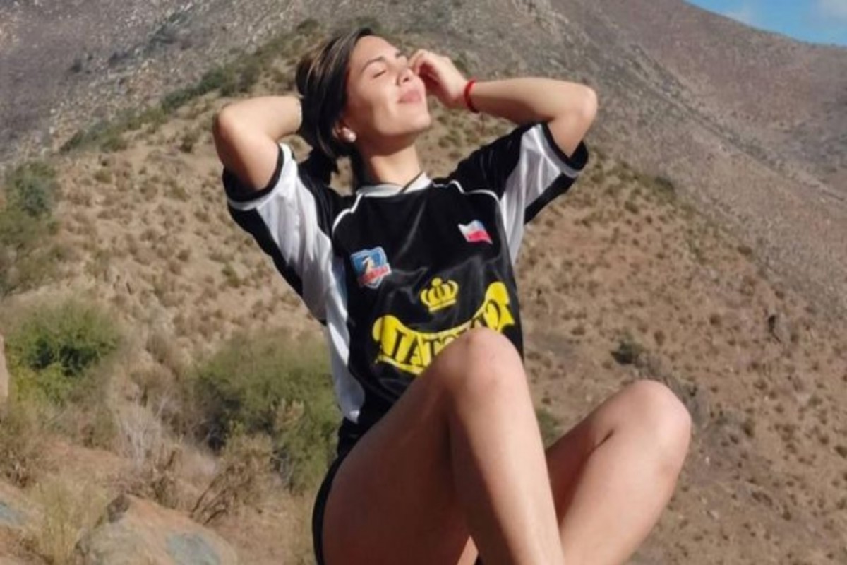Julissa Campos con las manos en el pelo mientras está sentada con la camiseta de Colo-Colo