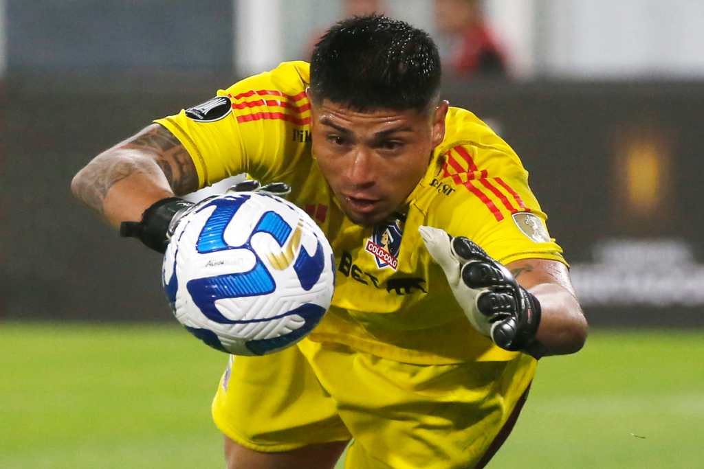 Brayan Cortés a punto de agarra un balón mientras defiende la camiseta de Colo-Colo.