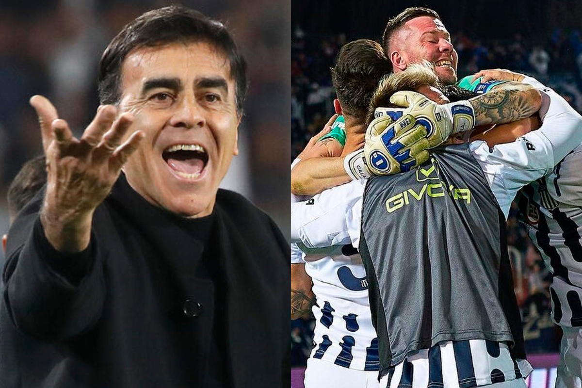 Primer plano al rostro exaltado de Gustavo Quinteros, mientras que en el sector derecho de la imagen se encuentran los jugadores de Talleres celebrando un gol abrazados.