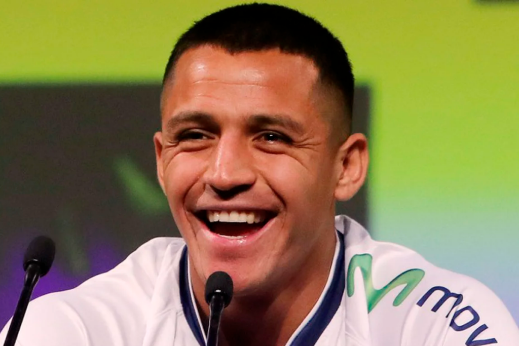 Alexis Sánchez sonriendo en plena conferencia de prensa.