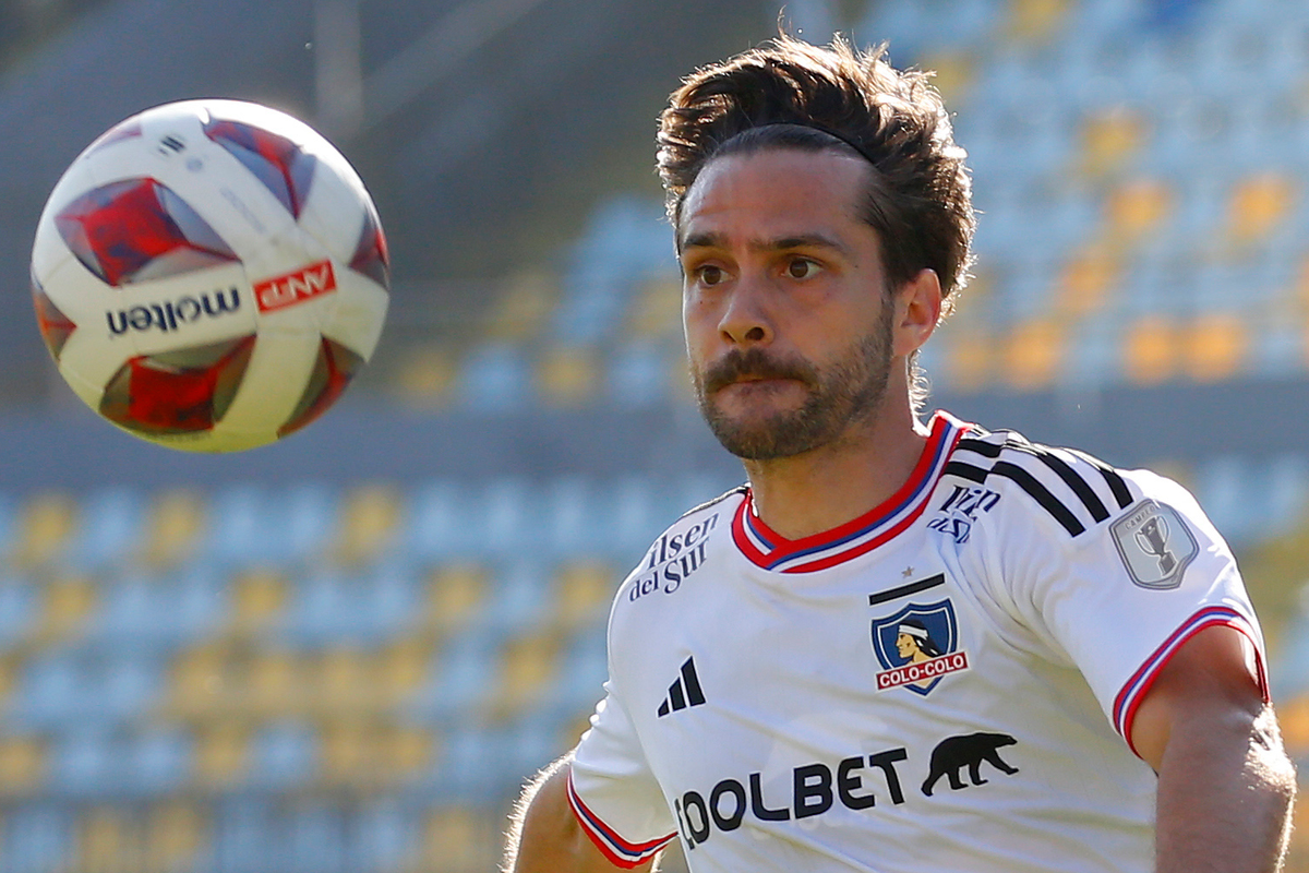 Agustín Bouzat observando fijamente un balón en el aire mientras defiende la camiseta de Colo-Colo.