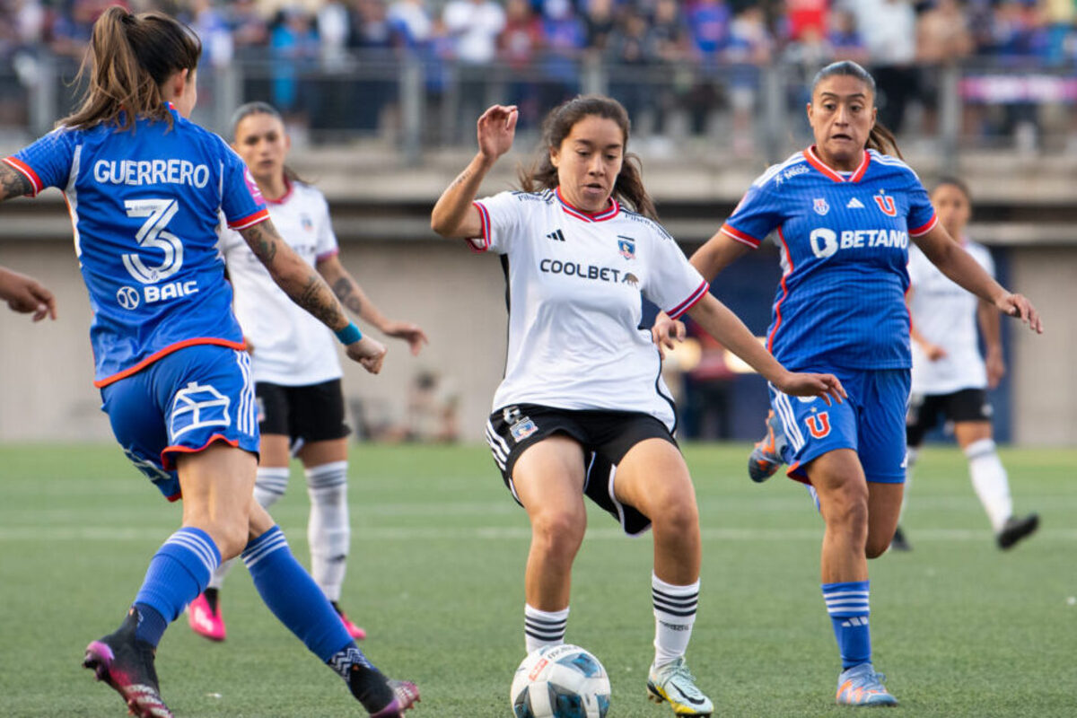 Jugadoras de Colo-Colo y Universidad de Chile disputando un balón.