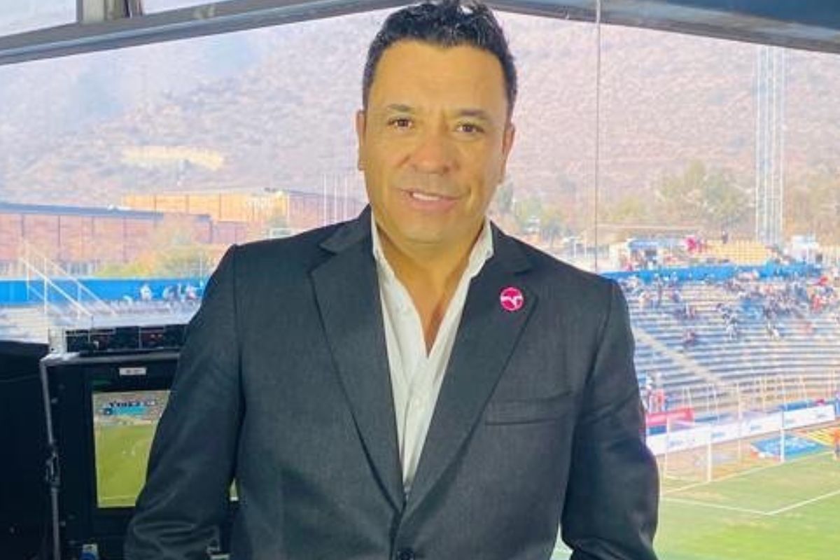 Claudio Palma con chaqueta y camisa en caseta de estadio