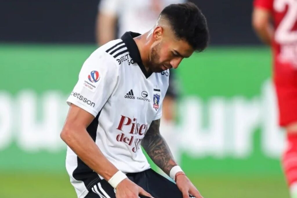 Juan Martín Lucero de rodillas con la camiseta de Colo-Colo