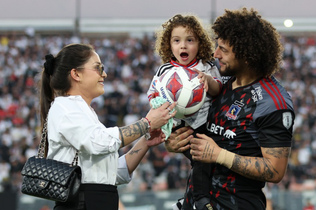 Maximiliano Falcón, Florencia Pouso y Domingo Falcón en medio de la conmemoración al jugador de Colo-Colo por sus 100 partidos oficiales.