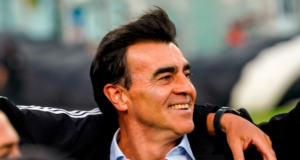 Gustavo Quinteros es abrazado y muestra una larga sonrisa en medio de la cancha principal del Estadio Monumental.