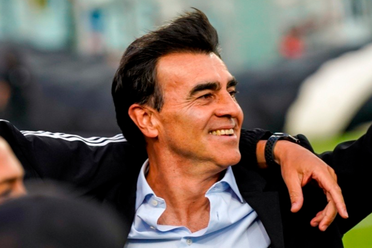 Gustavo Quinteros es abrazado y muestra una larga sonrisa en medio de la cancha principal del Estadio Monumental.
