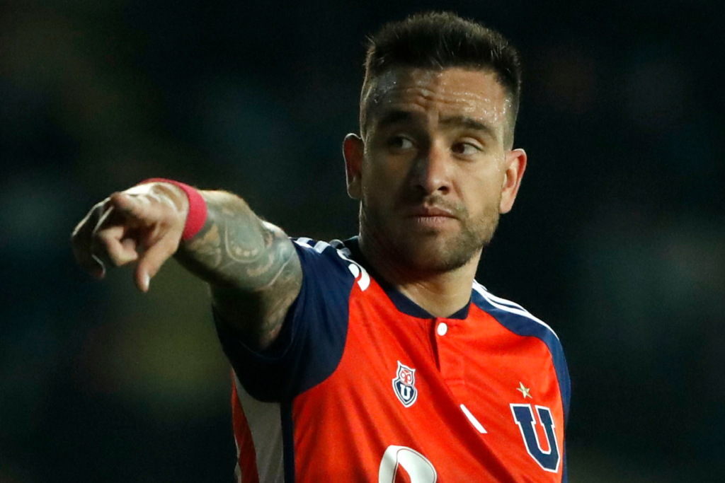 Matías Zaldivia repartiendo instrucciones y señalando con el dedo en medio de un partido de Universidad de Chile.