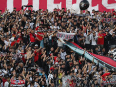 Hinchas de Colo-Colo alientan al primer equipo en el sector Arica del Estadio Monumental.