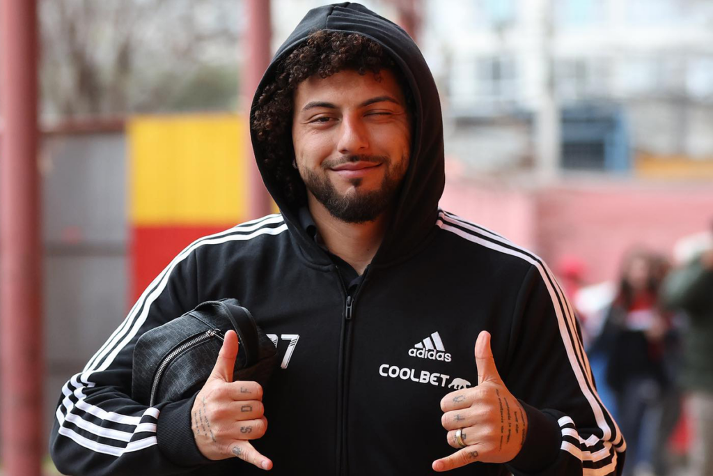 Maximiliano Falcón sonriendo y haciendo un gesto con sus dedos antes de afrontar un partido con la camiseta de Colo-Colo.