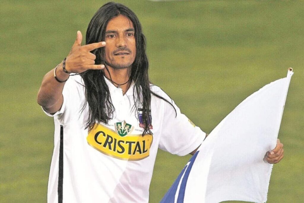 Gabriel Mendoza con una bandera de Colo-Colo durante una Noche Alba en el Estadio Monumental.