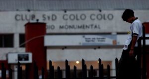 Postal de la fachada del Estadio Monumental y un hincha de Colo-Colo durante la quiebra del club.