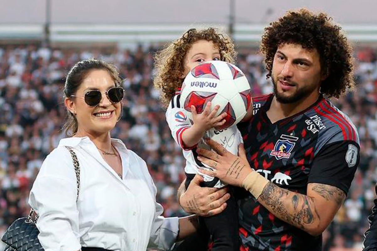 La familia de Maximiliano Falcón, compuesta por Florencia Pouso y Domingo Falcón sonríen en medio del homenaje al futbolista tras superar los 100 partidos oficiales con la camiseta de Colo-Colo.