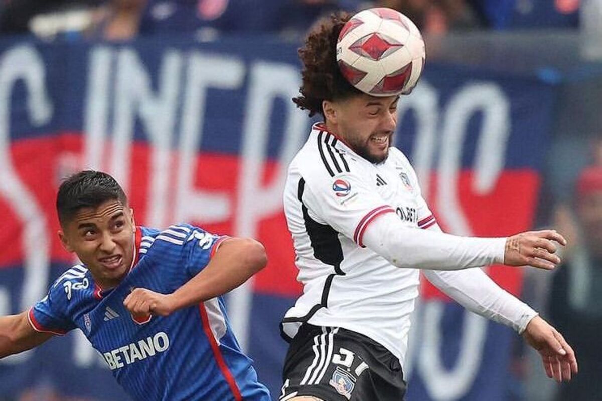 Maximiliano Falcón cabeceando el balón ante el acecho de Nicolás Guerra.