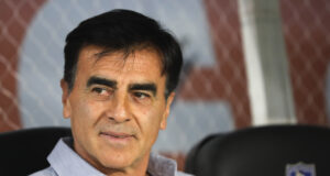 Gustavo Quinteros sonriendo mientras está sentado en la banca de Colo-Colo durante la temporada 2023.