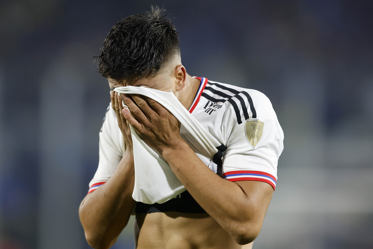 Damián Pizarro se cubre el rostro con su camiseta de Colo-Colo con clara señal de lamento y resignación.