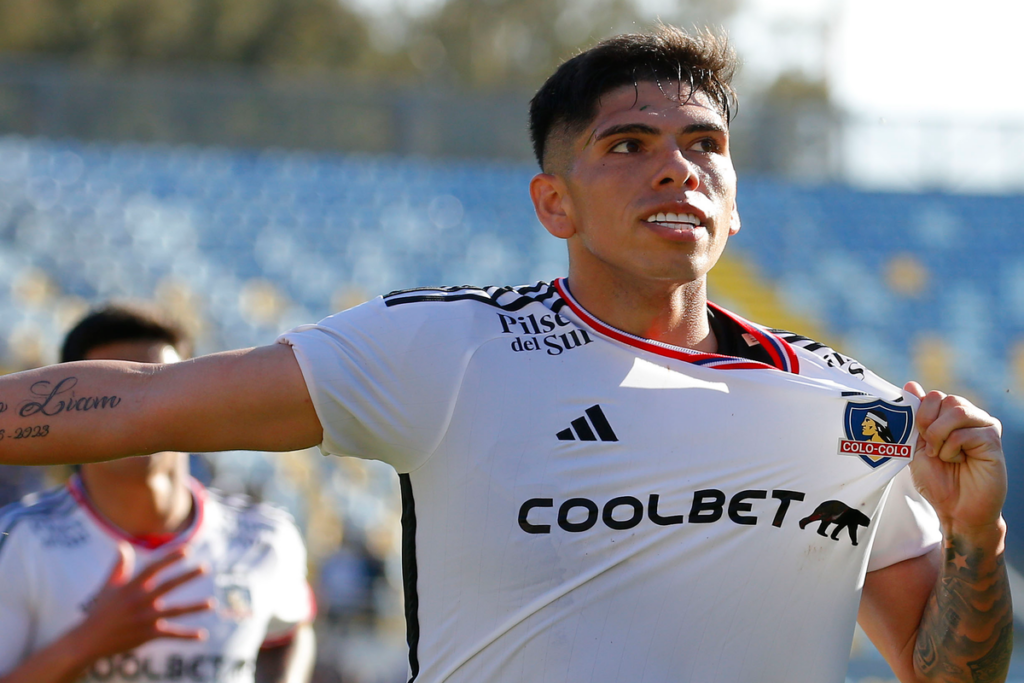 Carlos Palacios se agarra el escudo de Colo-Colo en plena celebración de un gol durante la temporada 2023.