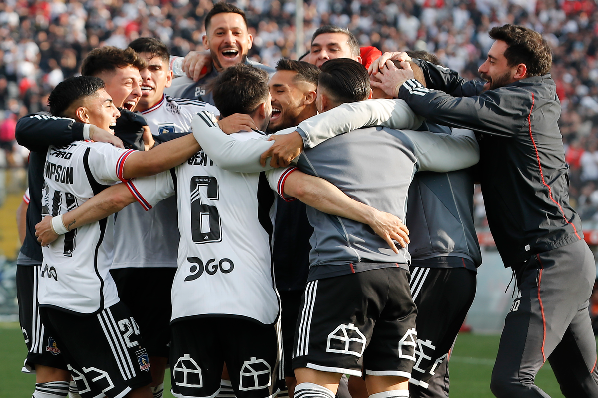 Futbolistas de Colo-Colo se abrazan y celebran un gol durante la temporada 2023.