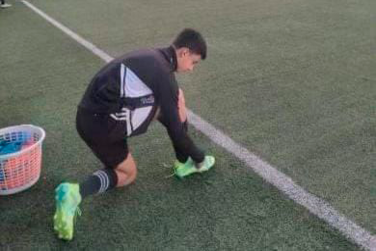 Gonzalo Barrientos se abrocha sus zapatos antes de comenzar un entrenamiento con la Sub 15 de Colo-Colo.