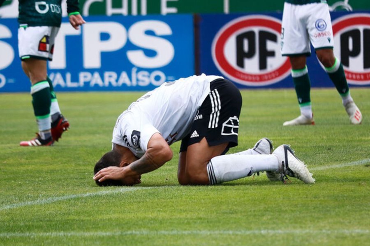 Futbolista de Colo-Colo de rodillas con la cabeza en el piso