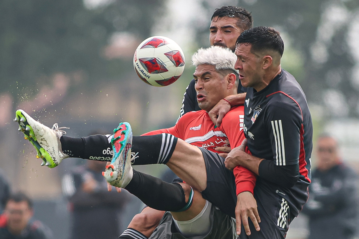 Jugadores de Colo-Colo disputando un balón contra uno de Palestino.