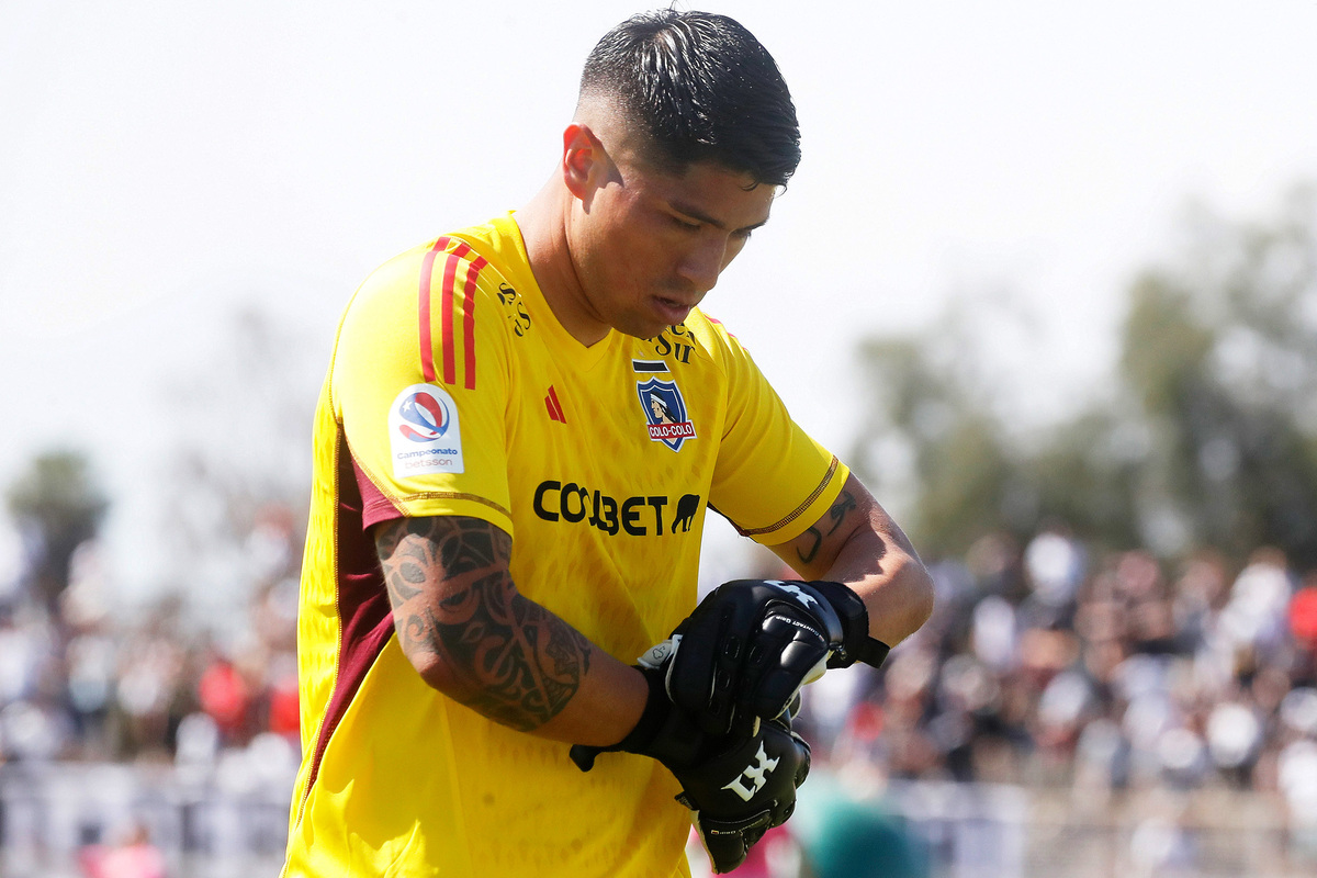 Brayan Cortés serio sacándose uno de sus guantes durante un partido de Colo-Colo.
