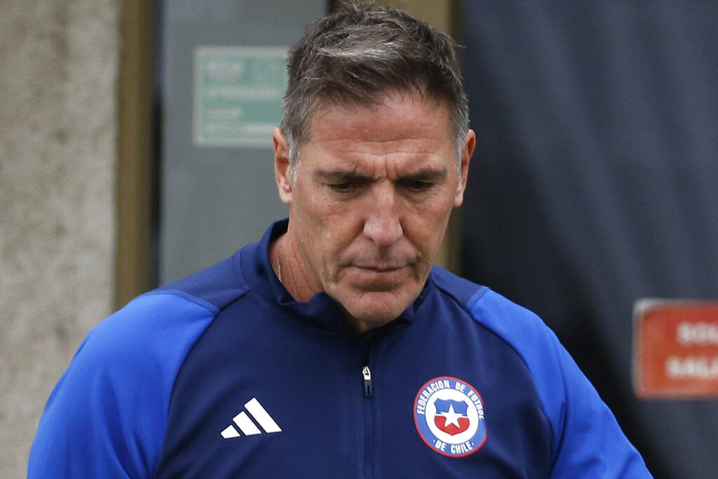 Eduardo Berizzo serio con un poler´n de la Selección Chilena.