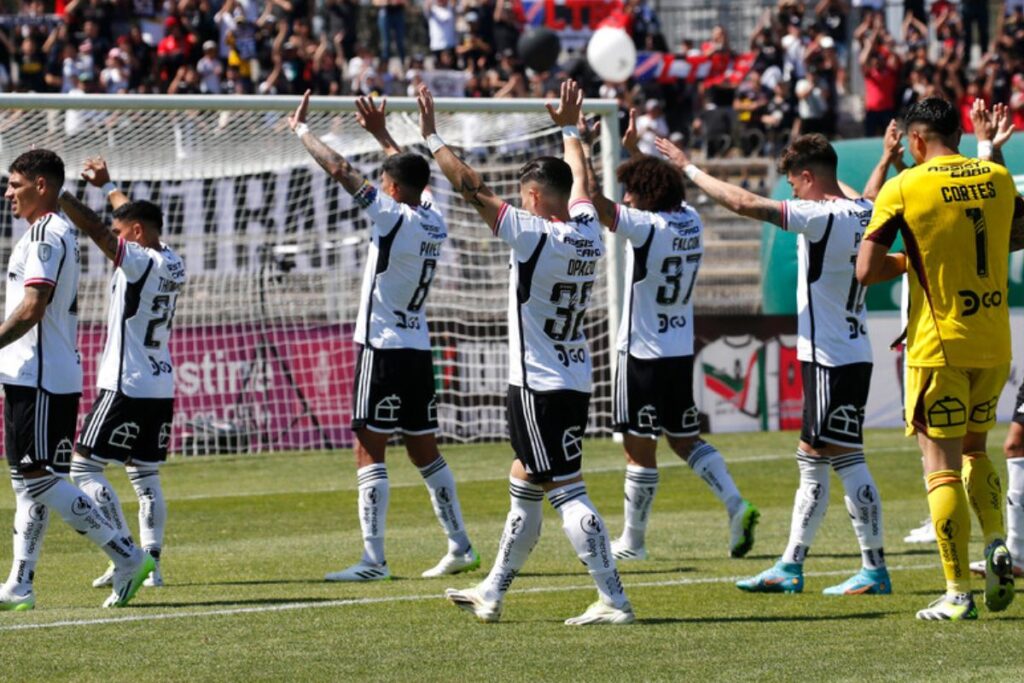 Jugadores de Colo-Colo en la cancha con los brazos levantados