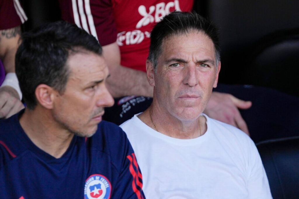 Eduardo Berizzo con polera blanca acompañado de un asistente.