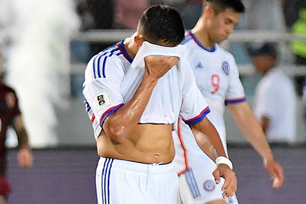 Alexis Sánchez se tapa el rostro con la camiseta de la Selección Chilena tras la derrota 3-0 sufrida a manos de Venezuela durante la temporada 2023.