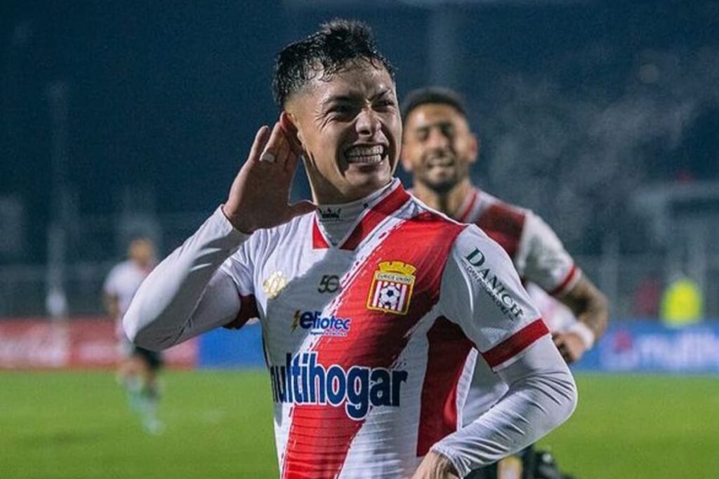 Primer plano a Cristián Zavala contento mientras celebra un gol de Curicó Unido con una mano en la oreja,