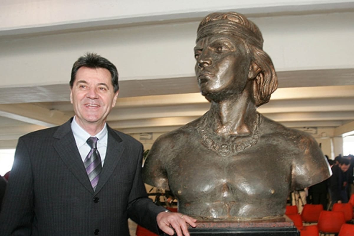 Mirko Jozic junto a una estatua de un Cacique en el Estadio Monumental.